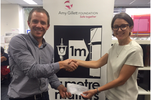 Bike Chaser co-founder Cameron Nicholls presenting Amy Gillett Foundation CEO Phoebe Dunn with our latest ad revenue donation.